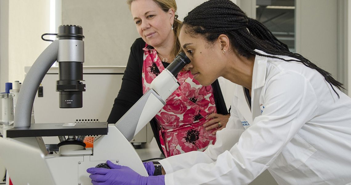 Faculty member teaches student in a lab setting